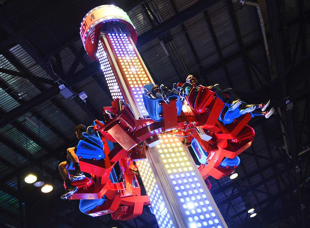 IAAPA Expo guests ride a midway exhibit.